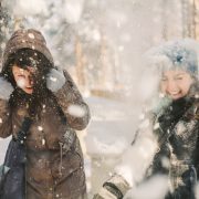 Two joyful friends having fun in the snow during on a cold winter's day. Christmas can be stressful so it's important to spend some time to relax and take care. This post shows you one great way how to Stay Relaxed At Christmas Sandra Harewood Counselling
