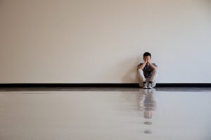 A sad man sitting against a wall - The Critical Voice of Toxic Shame And How To Silence It- Sandra Harewood Counselling