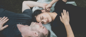 Man And Woman Laying Down Head To Head Holding Hands - Why Attachment Styles Matter to Your Relationship - Sandra Harewood Counselling
