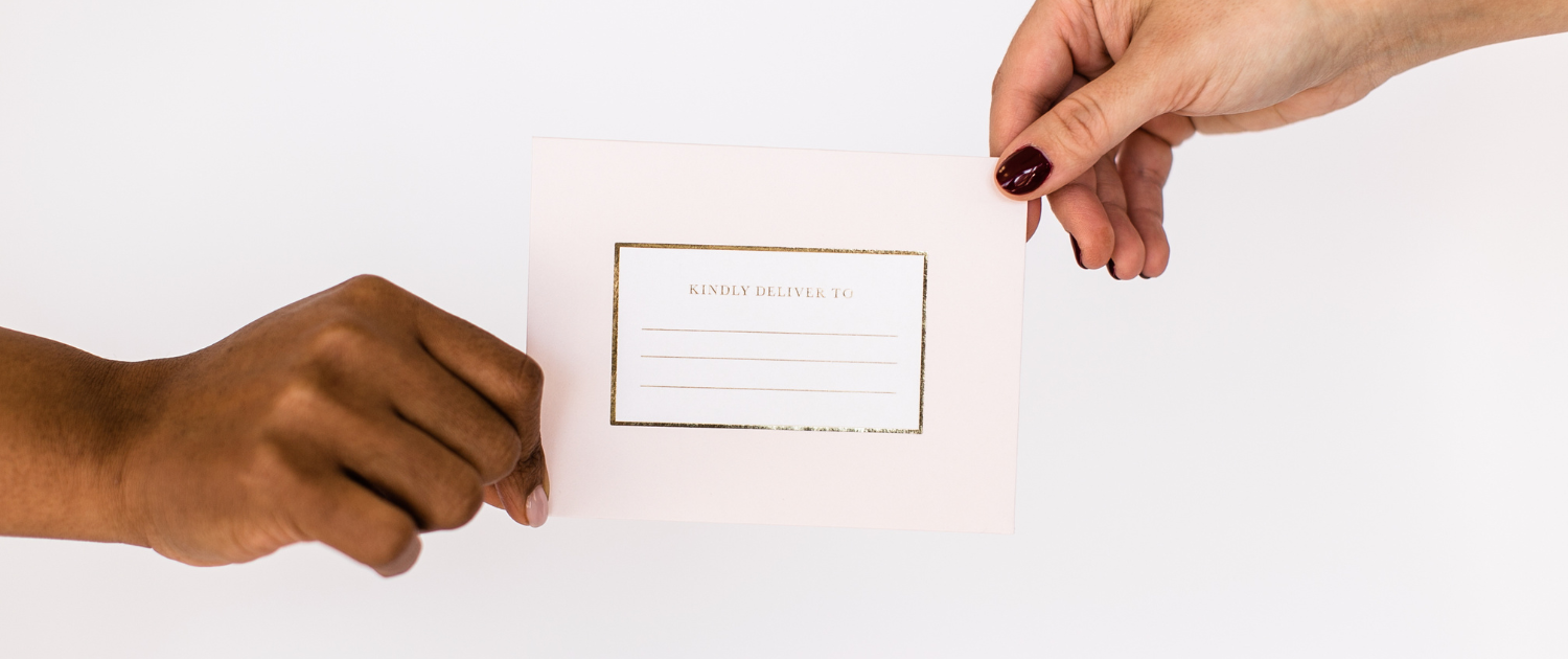 An invitation card is being held by two women - one black and one white. Why attachment styles matter in your relationship - Sandra Harewood