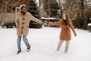 A young diverse couple plays in the snow outside - Couple Counselling - Sandra Harewood Counselling