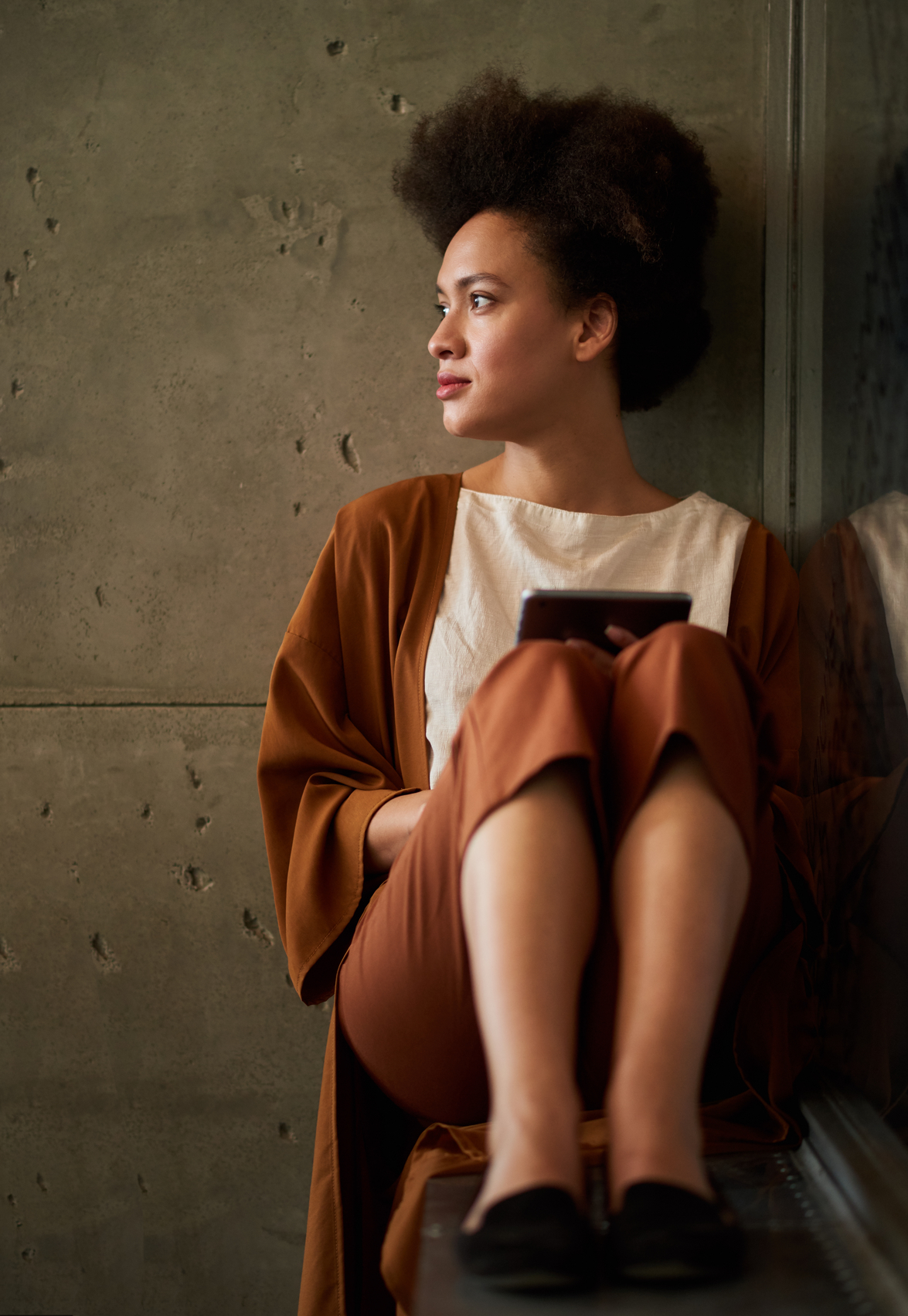 Sandra Harewood Coaching & Counselling Home Page Young woman sitting, holding digital tablet in her hands - Sandra Harewood Coaching & Counselling