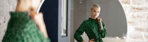A woman in a green dress is looking at herself in the mirror - Taking Ownership The Transformative Power of Responsibility in Marriage
