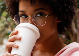 Woman taking a selfie on a smartphone while drinking a coffee - Sandra Harewood.
