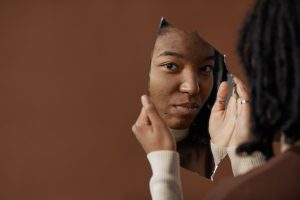 Woman looking in broken mirror