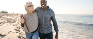 happy interracial couple senior couple on the beach - Sandra Harewood