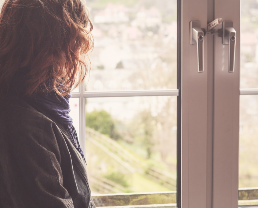 Reflective woman Looking Out Of A Window