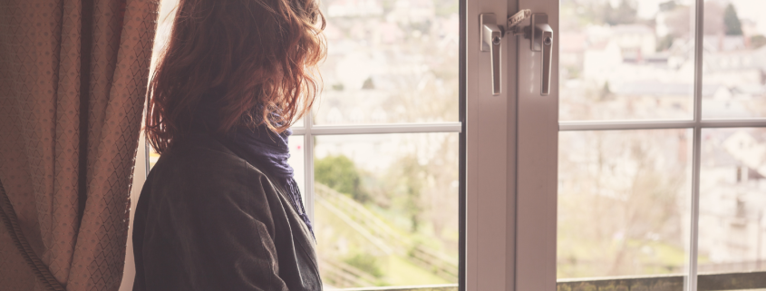 Woman siting alone looking through a window - Why Midlife Marriages Face Crisis—and How to Navigate Them with Compassion - Sandra Harewood