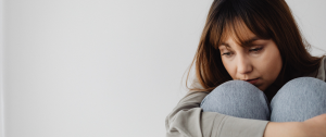 Bored But Still Together? Sad Woman Sat Hugging Here Knees - What Boredom in a Good Relationship Might Really Mean - Sandra Harewood