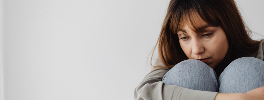 Bored But Still Together? Sad Woman Sat Hugging Here Knees - What Boredom in a Good Relationship Might Really Mean - Sandra Harewood