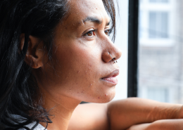 thoughtful black woman looking out of a window