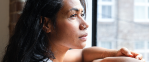 thoughtful black woman looking out of a window