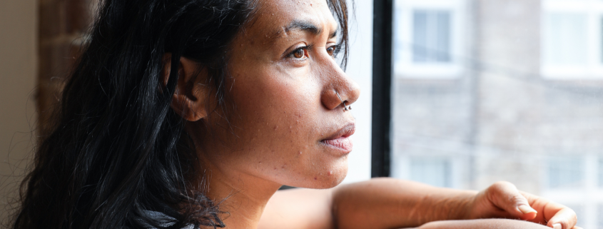 thoughtful black woman looking out of a window