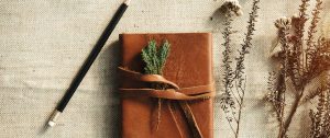 A closed leather journal with a pencil on a desk, symbolising reflection, closure, and new beginnings after the end of a marriage