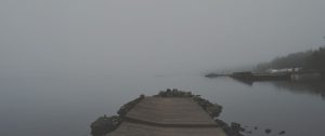 A quiet pier at dusk over calm water, representing reflection, endings, and the possibility of peace after a marriage