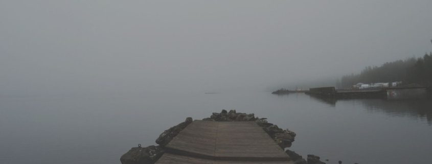 A quiet pier at dusk over calm water, representing reflection, endings, and the possibility of peace after a marriage