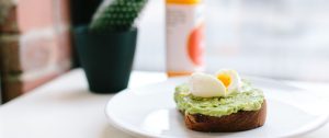 Soft boiled egg and sliced avocado on toasted sourdough, served on a white plate. A simple, nourishing breakfast that symbolises balance and self-care.
