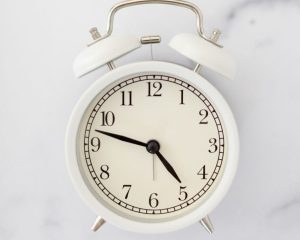 An alarm clock on a table symbolising the passing of time and seasonal change, inviting reflection