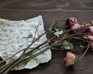 A love letter and dried roses symbolising the bittersweet process of letting go — divorce and separation counselling.
