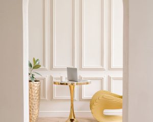 View through an open archway into a softly lit room with a gold table, symbolising openness, invitation, and the space empathy creates in relationships.