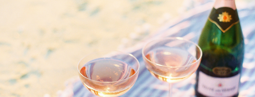 Two filled champagne glasses and a bottle of champagne symbolising social drinking and the early signs of problem drinking in midlife women.
