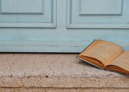 Open book on the step of an antique light blue door, symbolising reflection at a relationship crossroads