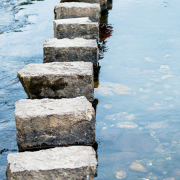 Stepping Stones On the Water Stepping stones crossing calm water, symbolising the gradual process of making relationship decisions with clarity and confidence.